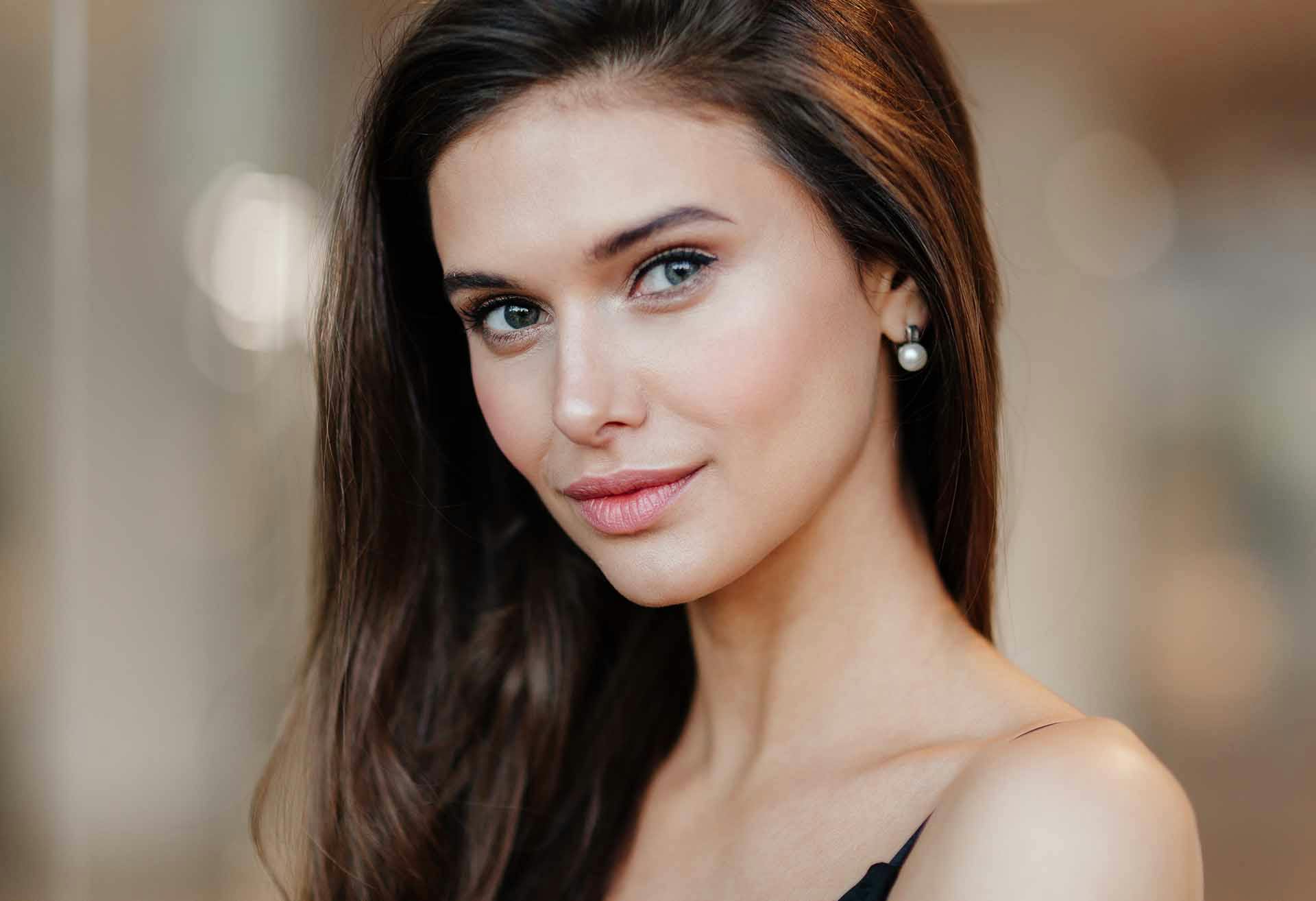 Woman with dark hair, looking sidelong at the camera