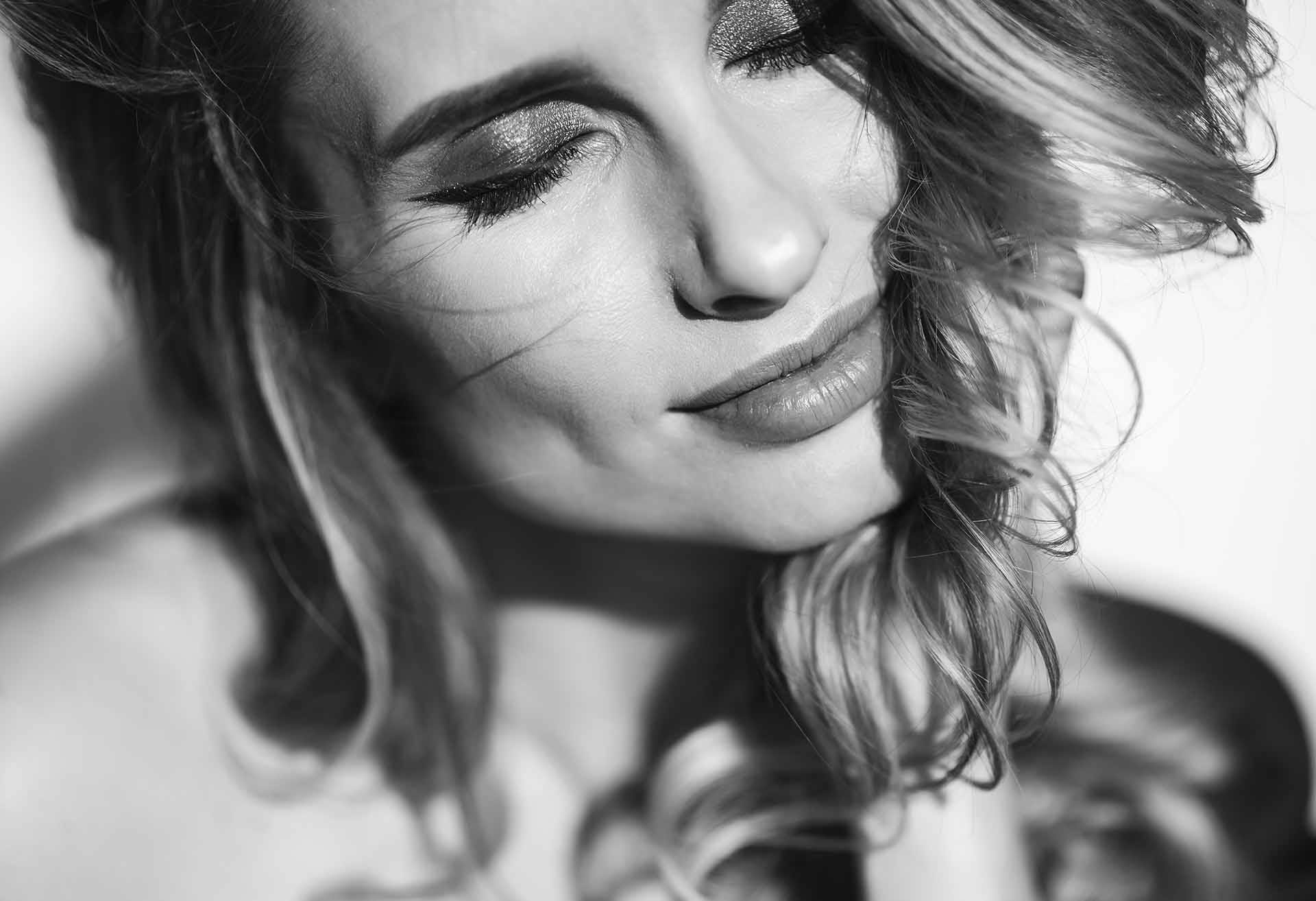 Black and white photo of a woman with her eyes closed
