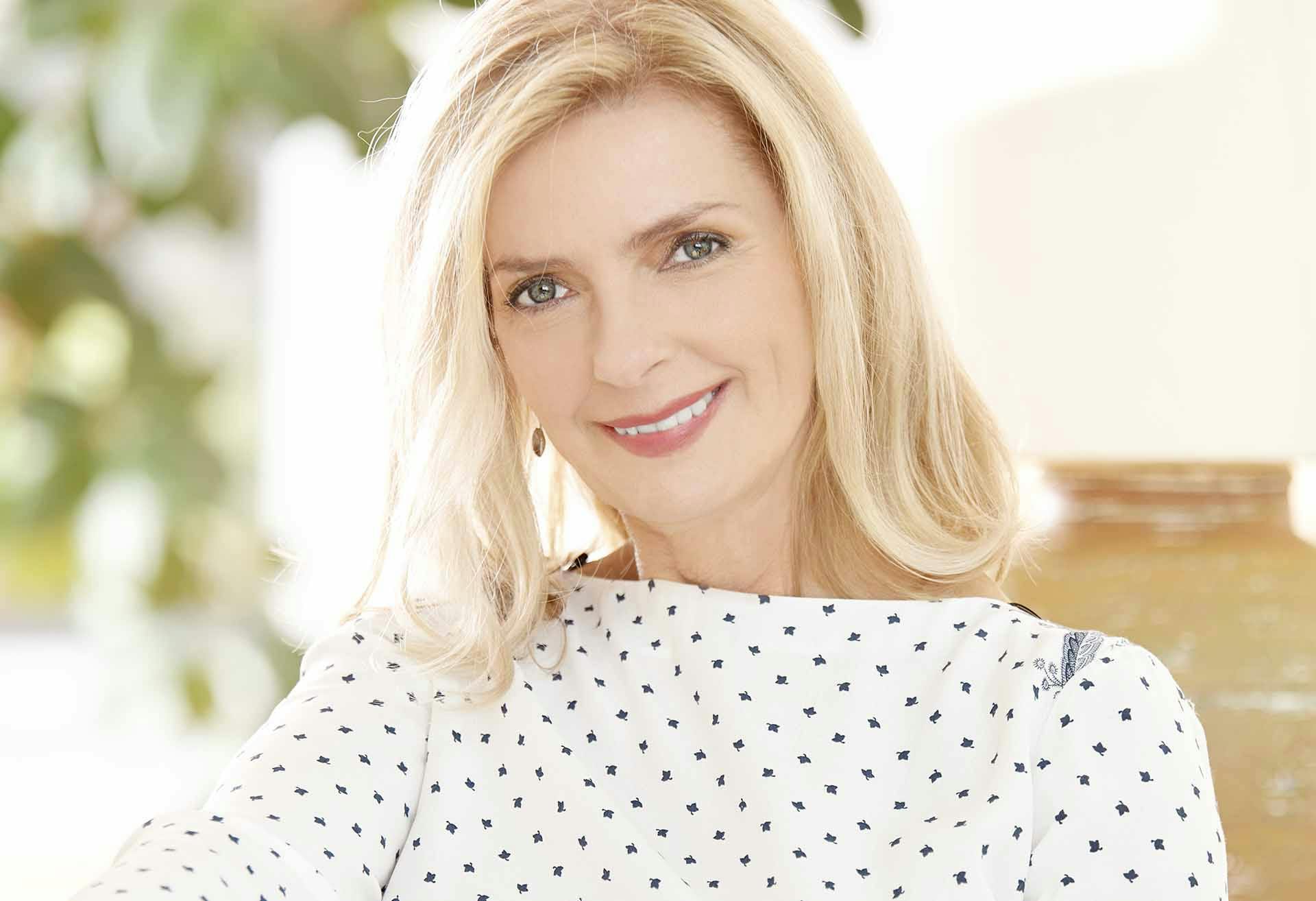 Woman with blond hair smiling into the camera