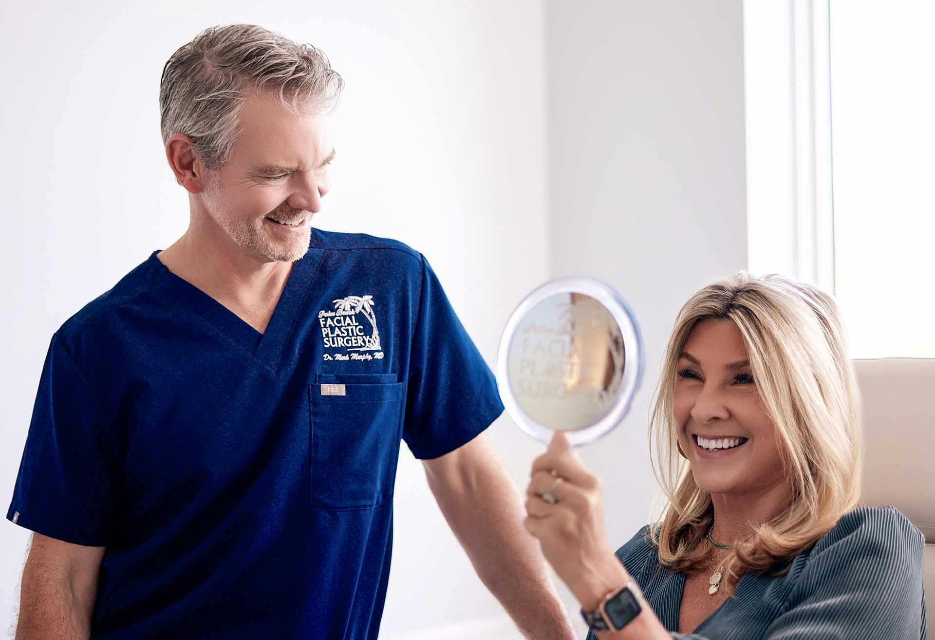 Dr. Mark Murphy standing next to a patient looking in the mirror