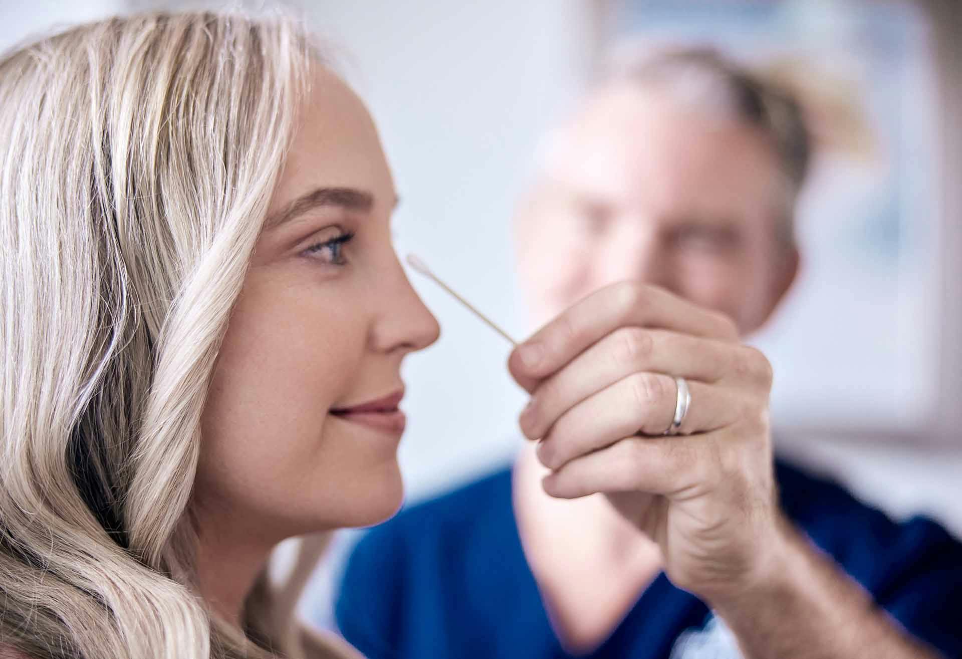 Dr. Mark Murphy holding a q-tip to a patient's face