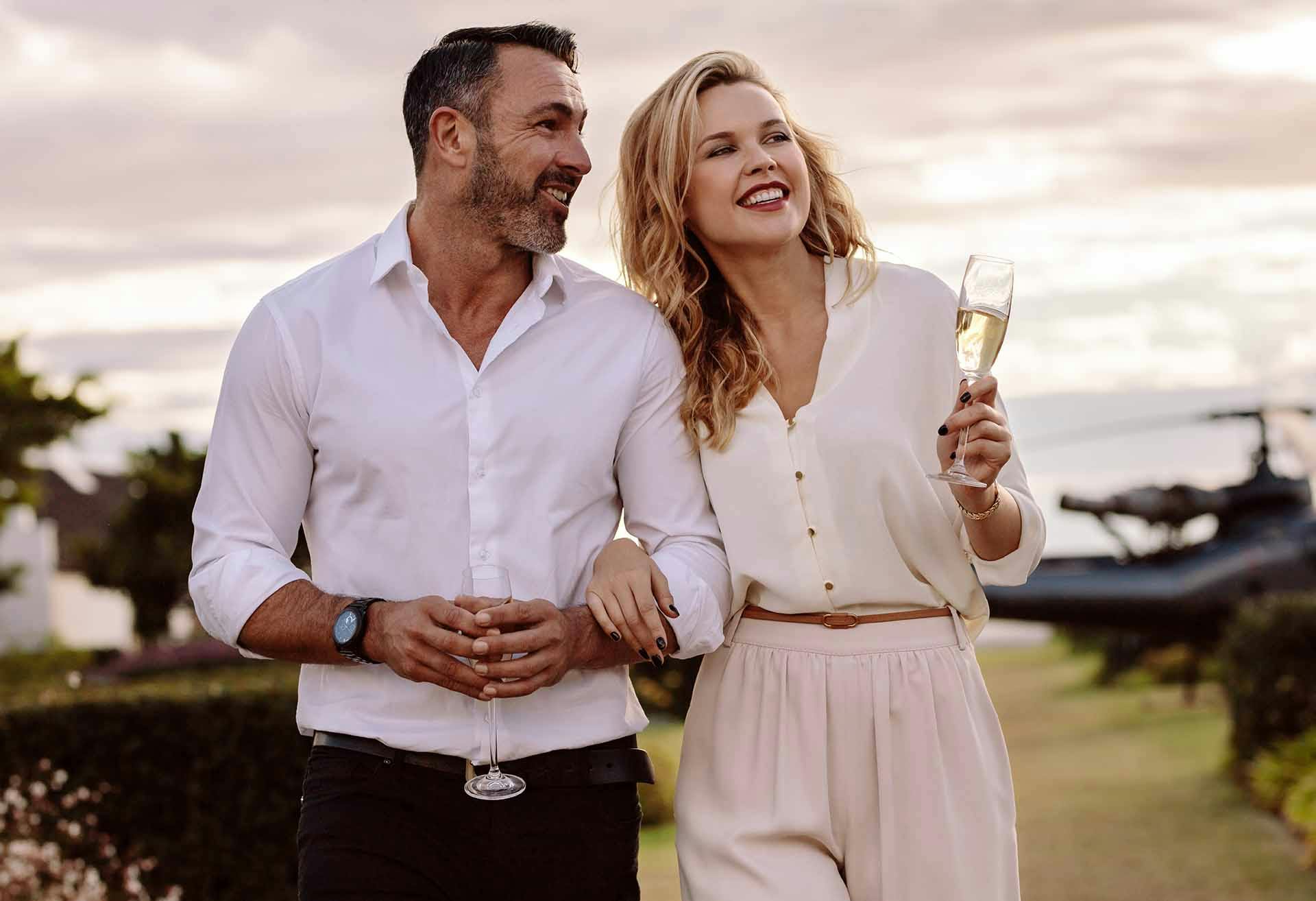 Man and woman with arms clasped, woman holding a glass of wine