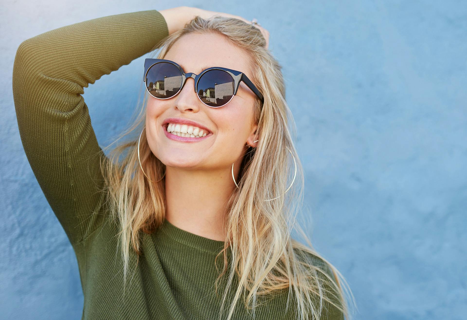Woman with sunglasses on, smiling