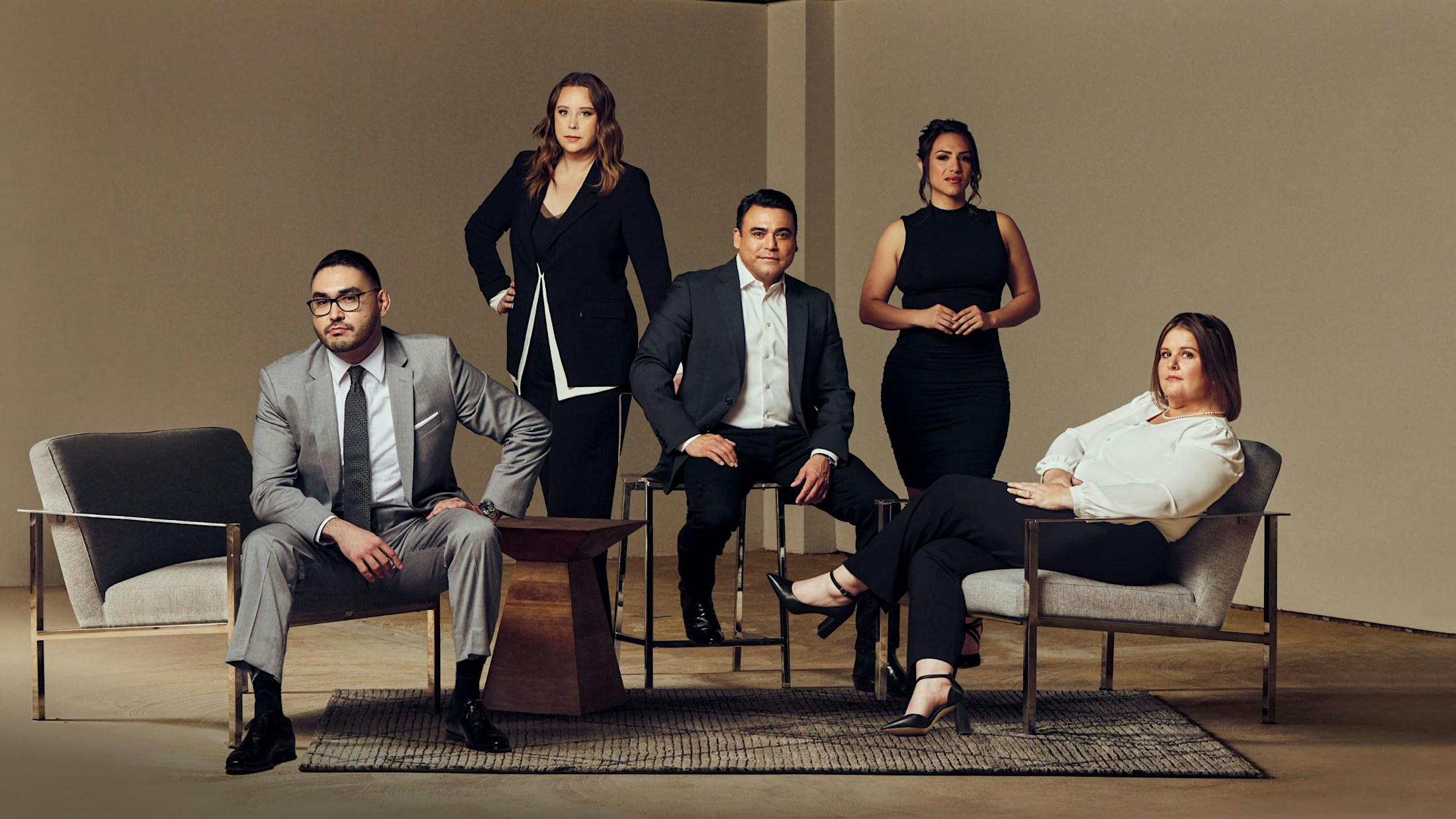 The Espinoza & Brock legal team sitting and standing together