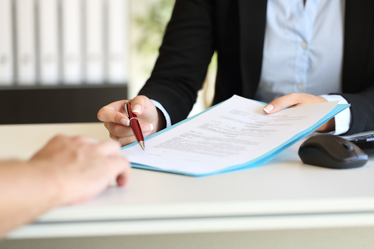 Woman holding a pen to a sheet of paper