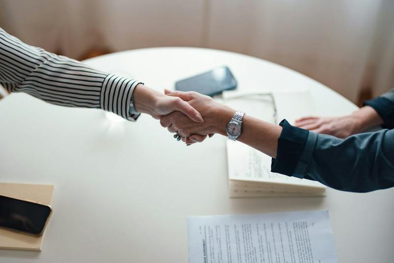 people shaking hands across a table