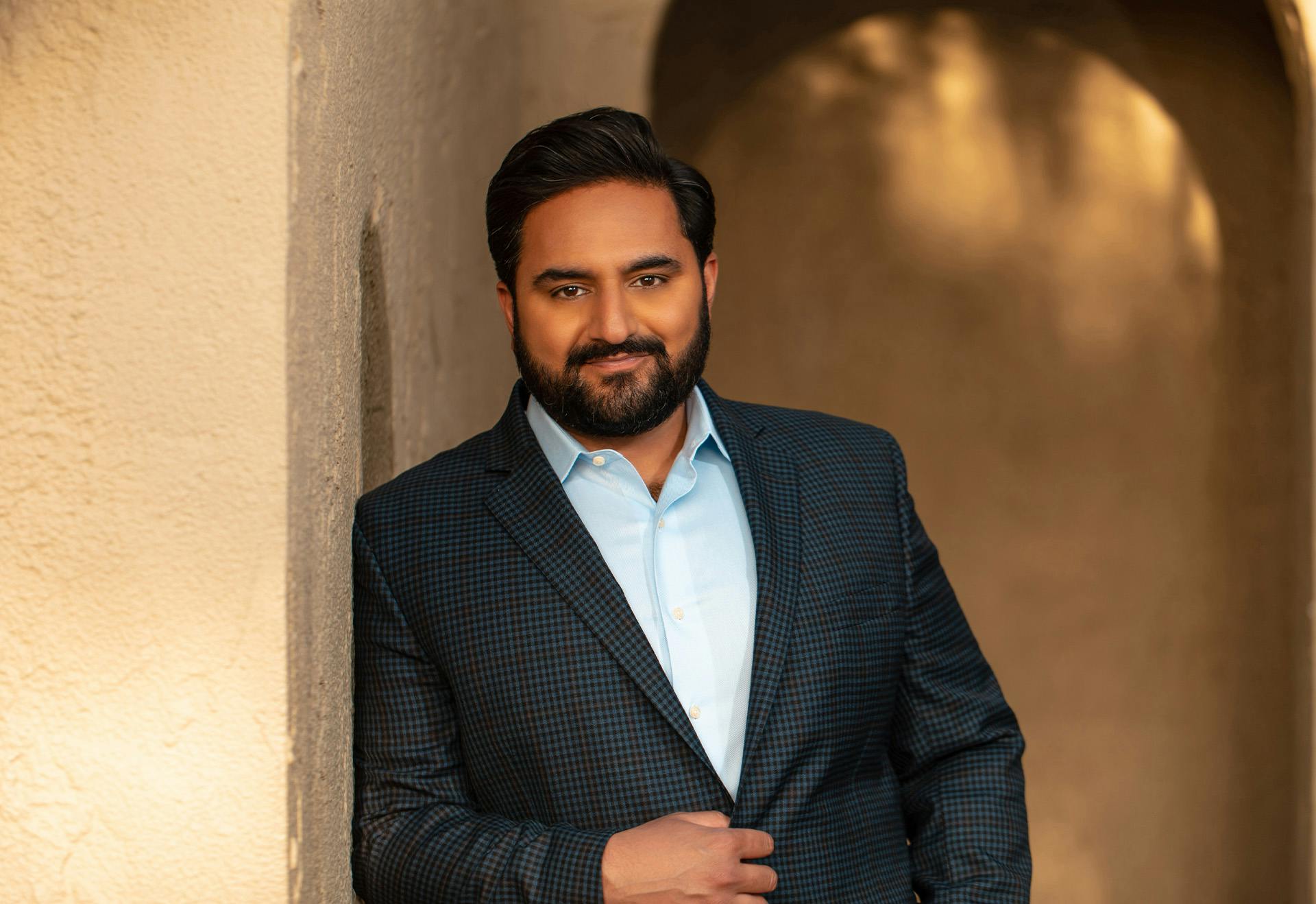 Doctor Sharma Leaning Against the Wall and Looking at the Camera