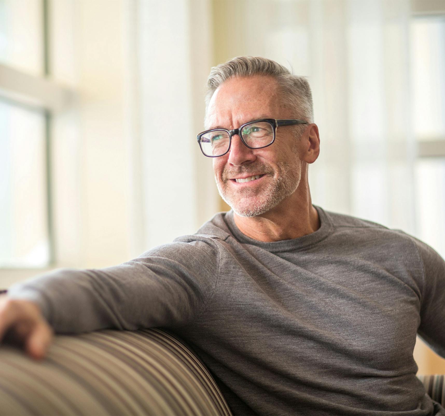 A man with glasses smiling