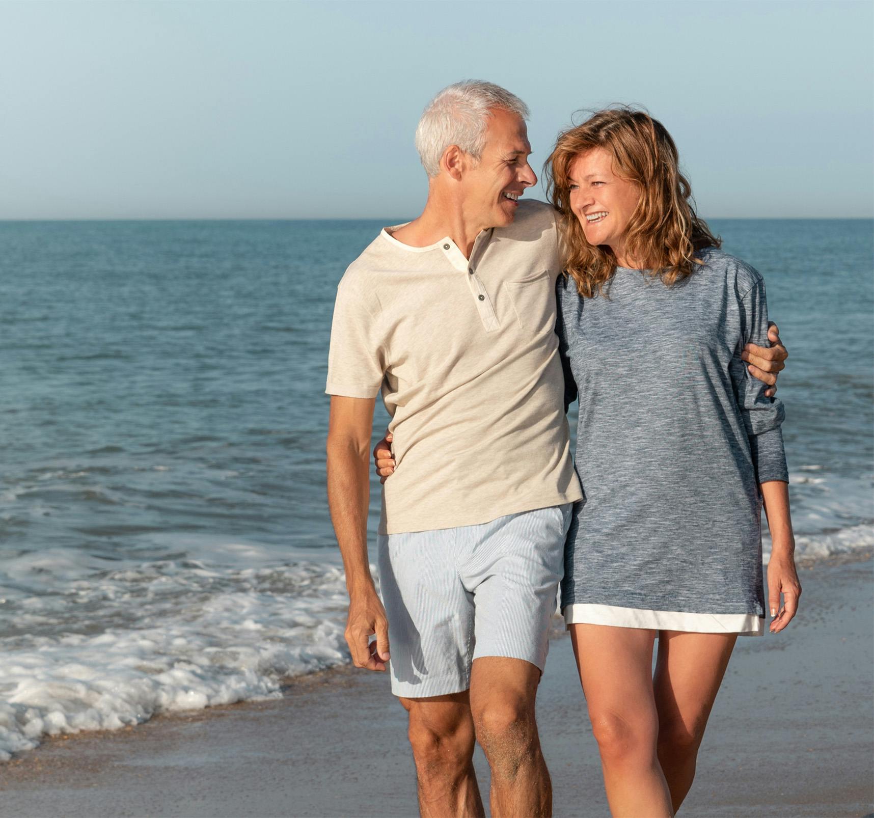 An older couple walking together on a beach