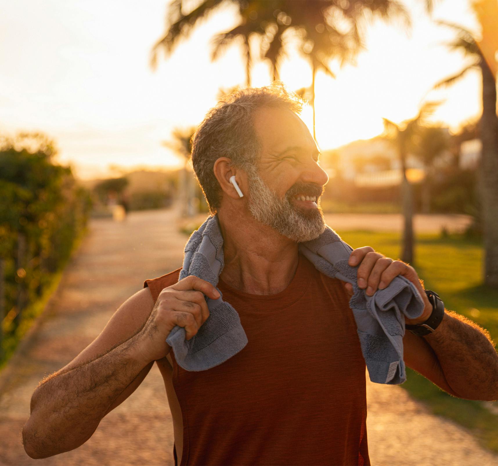 Older man with a towel around his neck smiling