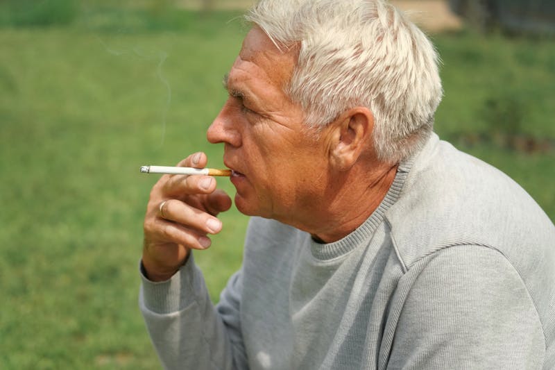 An older man smoking a cigarette