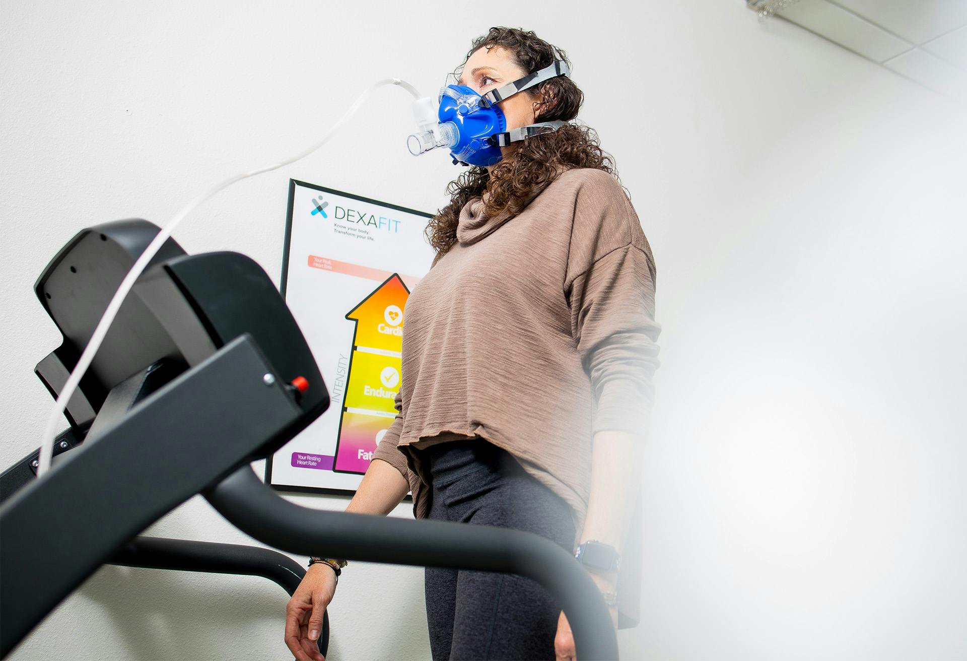 Woman with a mask walking on treadmill