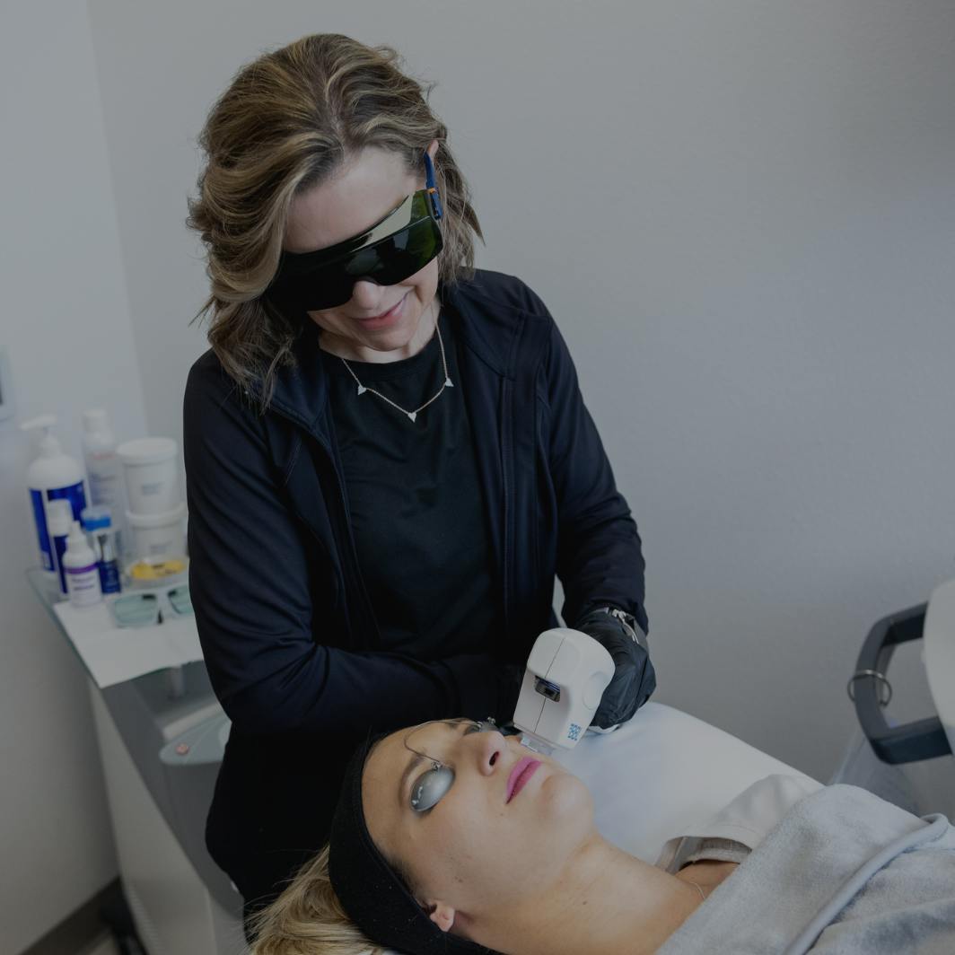 Women performing laser skin rejuvenation treatment