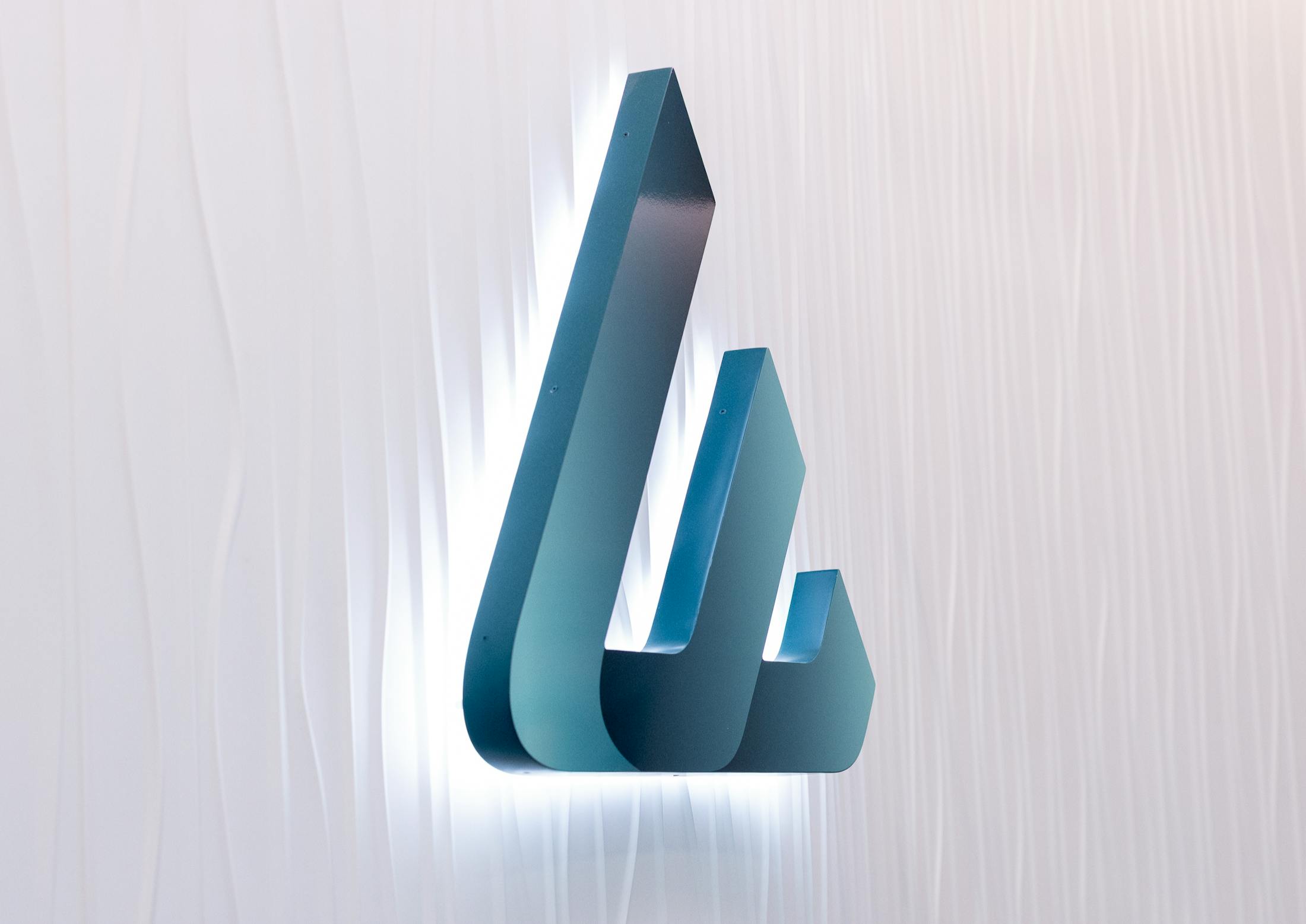 3D green abstract logo on a light textured background