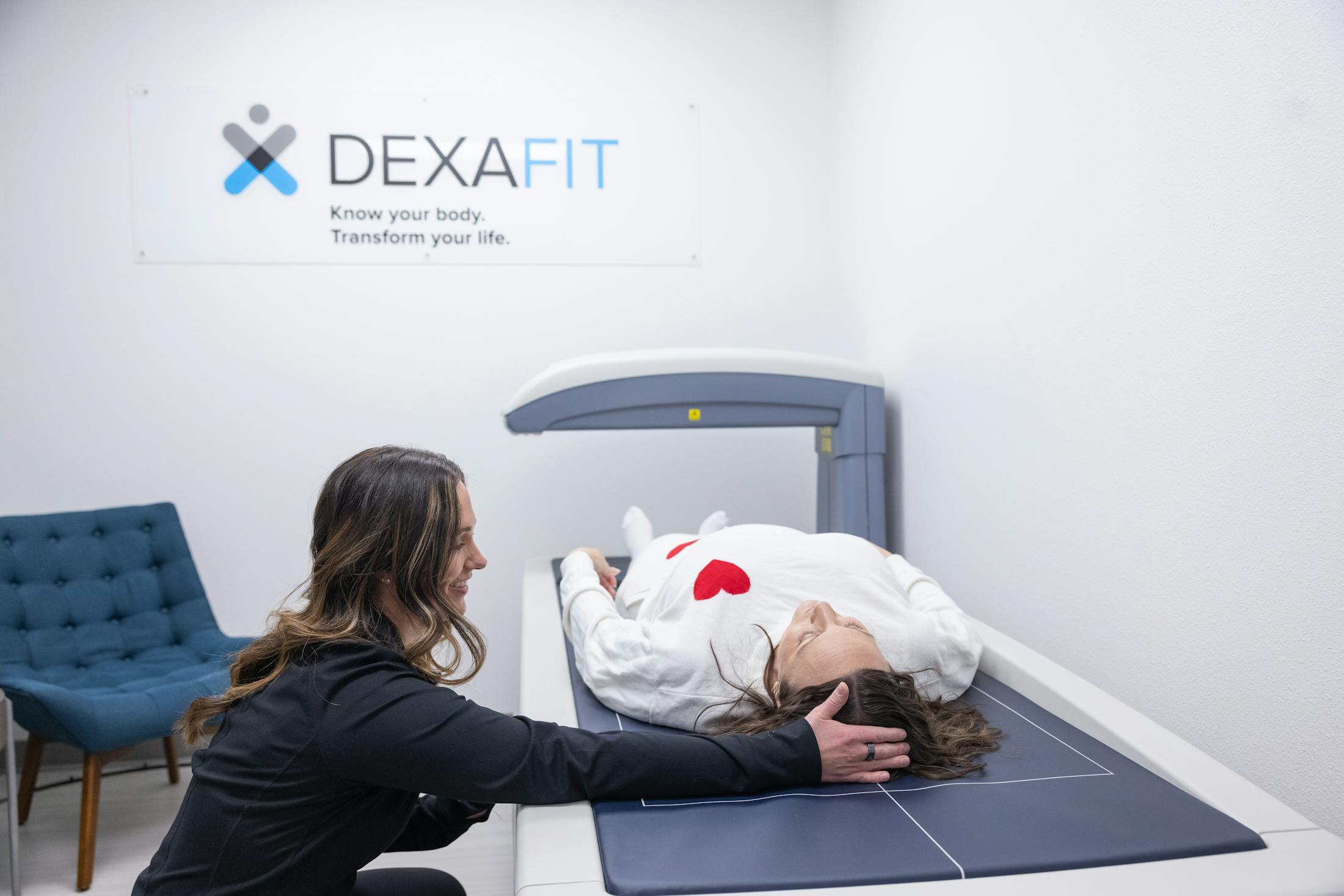 Women assisting patient on DexaFit scanner