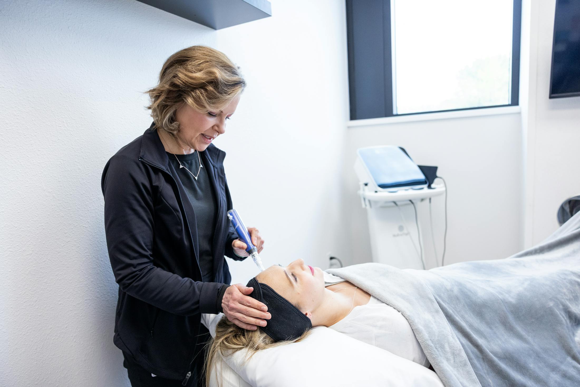 Women perfomring microneedling on patient