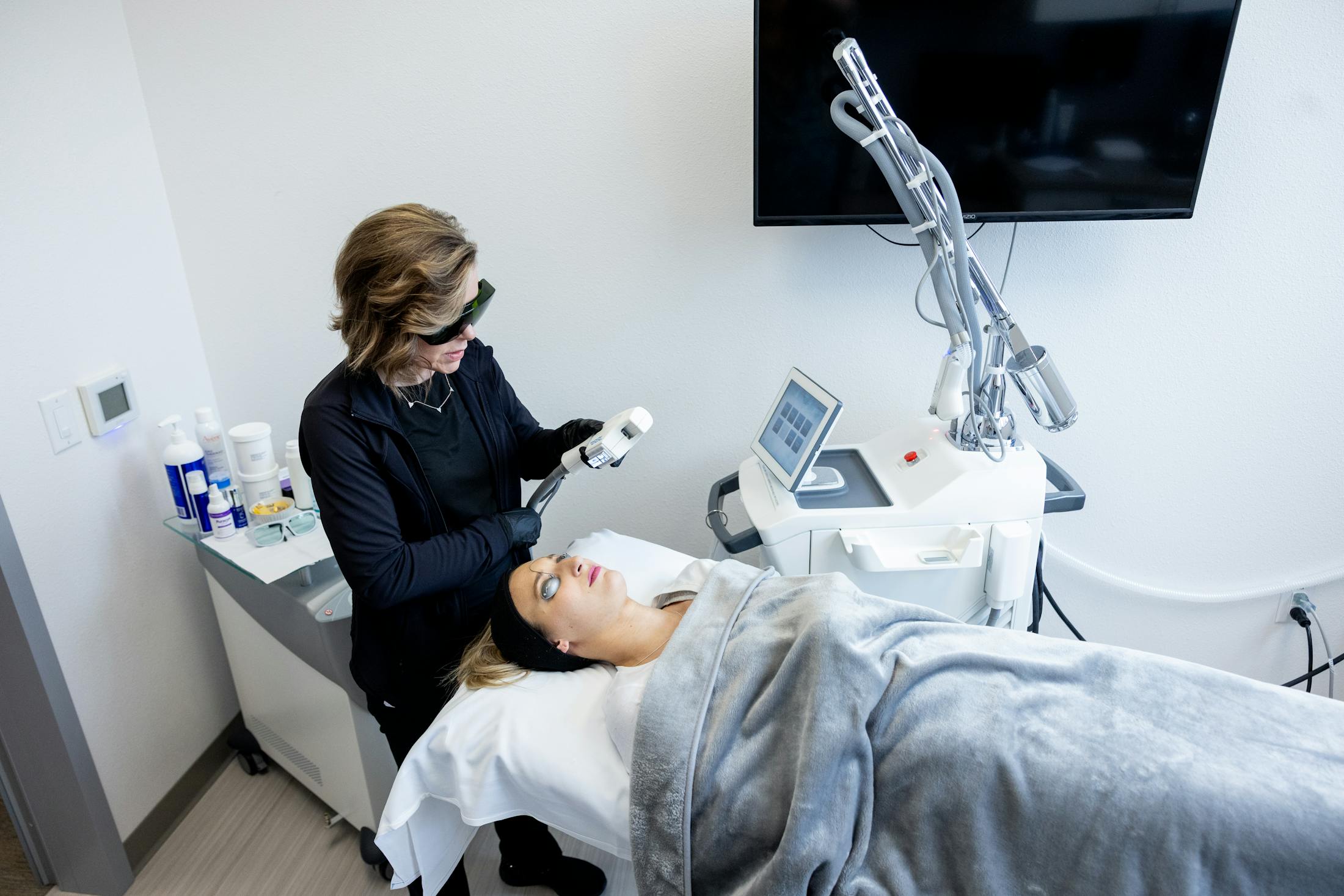 Women performing laser on patient