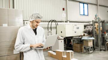 food safety worker on laptop in warehouse