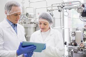 two food safety workers looking at results on a tablet together