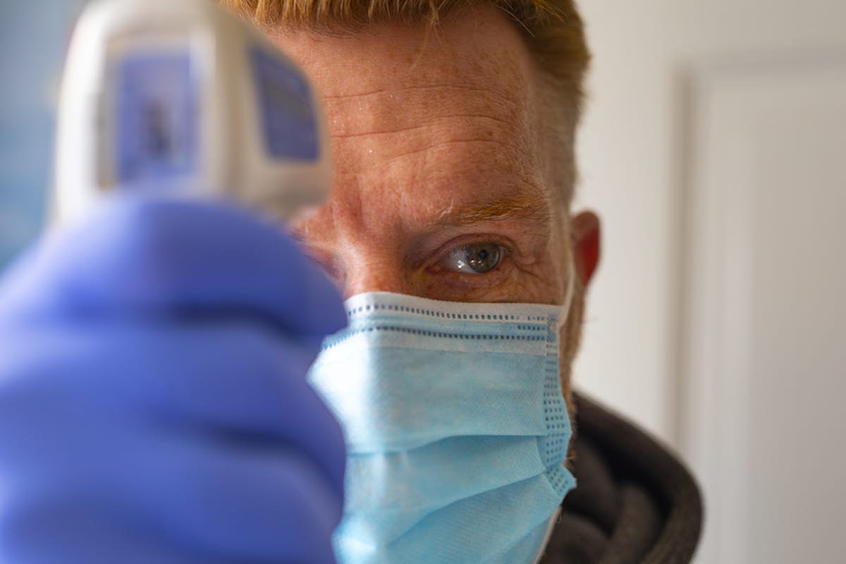 doctor taking person's temperature
