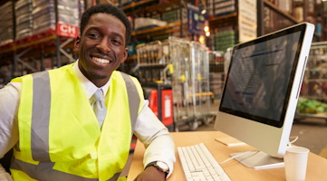 man smiling in warehouse at desk