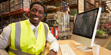 man smiling in warehouse at desk