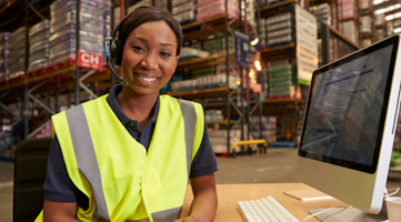 woman smiling in warehouse at desk