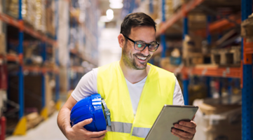 man with hard hat and tablet in warehouse