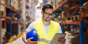 man with hard hat and tablet in warehouse