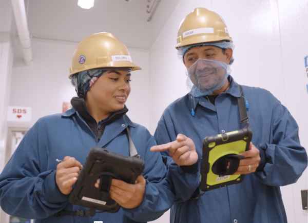 Two supervisors discussing real-time data on a tablet