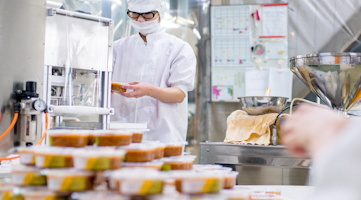 Quality operator checking food packaging in product batch.