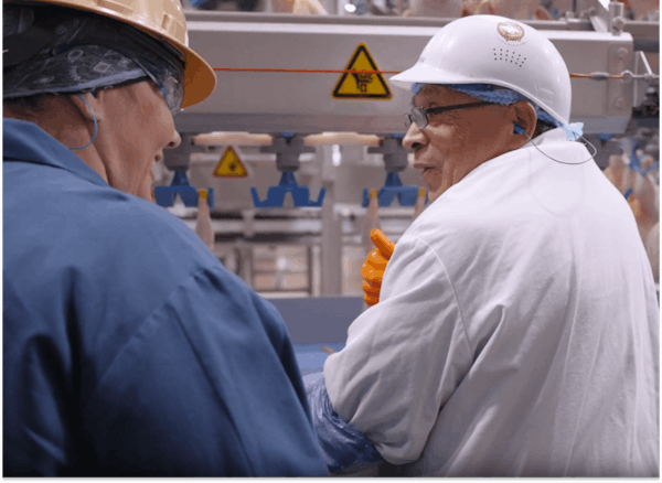 An operator and supervisor talking on the plant floor
