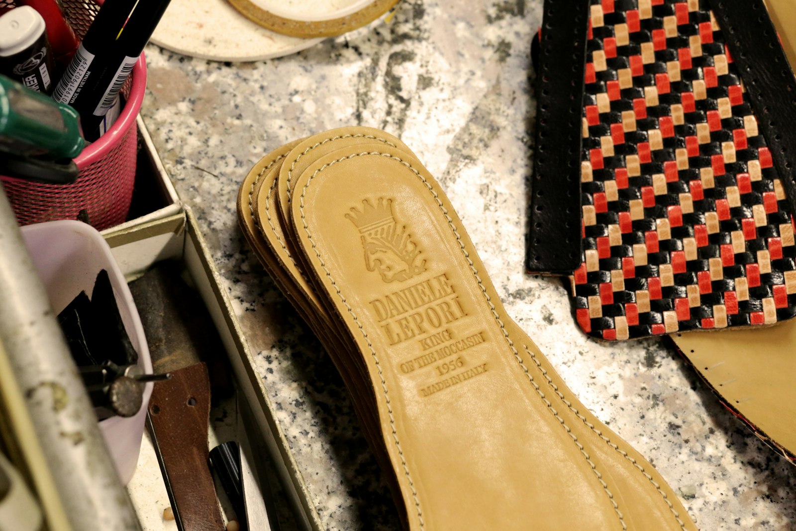 soletti interni delle scarpe Lepori collezione king of moccasins appoggiati al piano di lavoro .