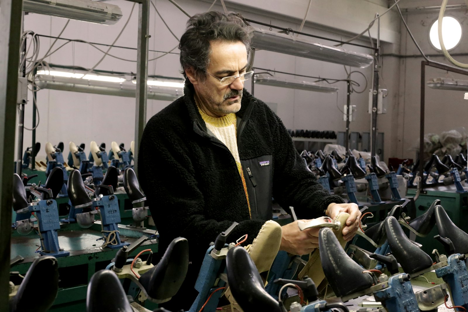 Daniele Lepori fotografato di tre quarti mentre si occupa della stiratura di una scarpa.