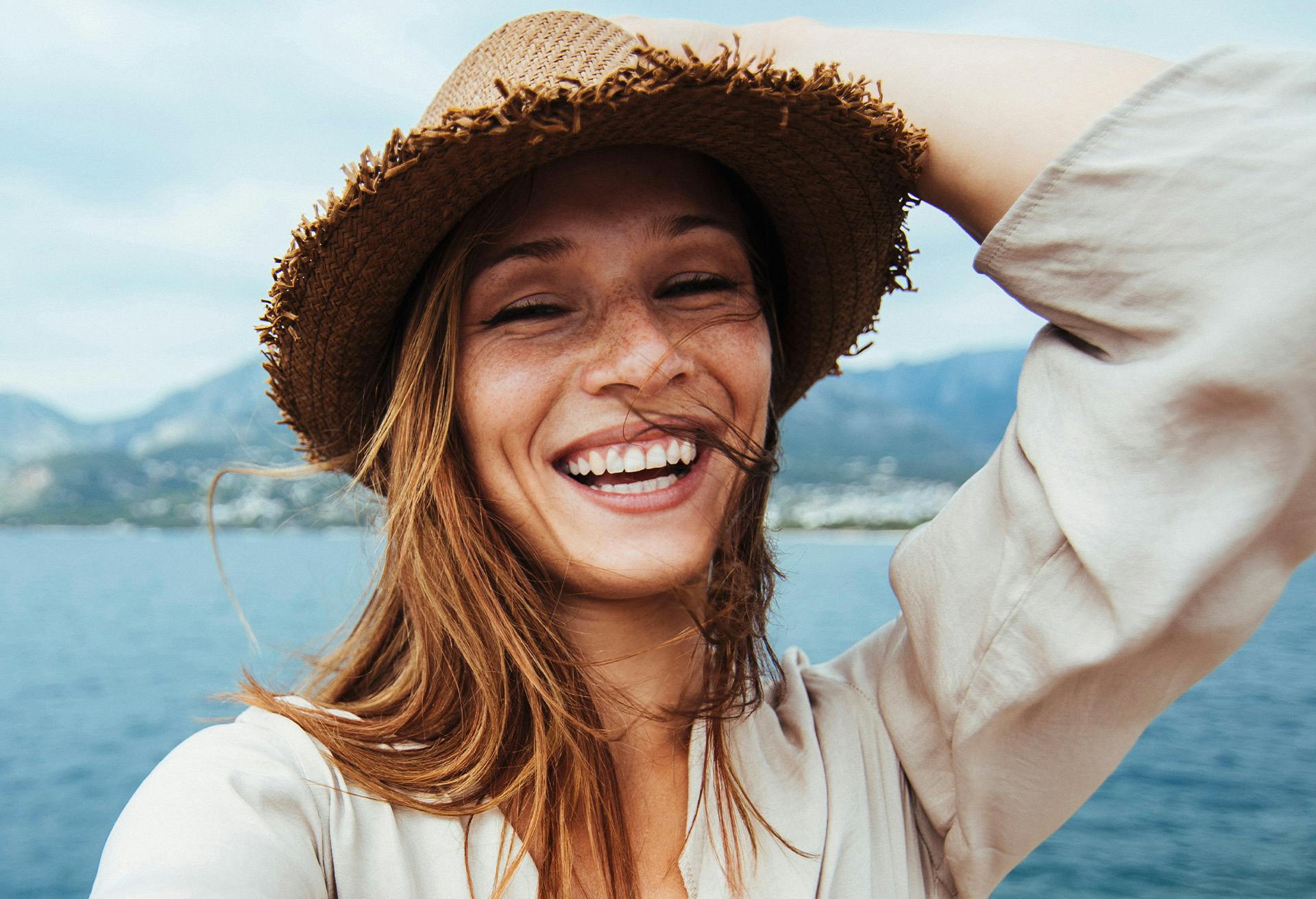 Woman smiling wearing a straw hat