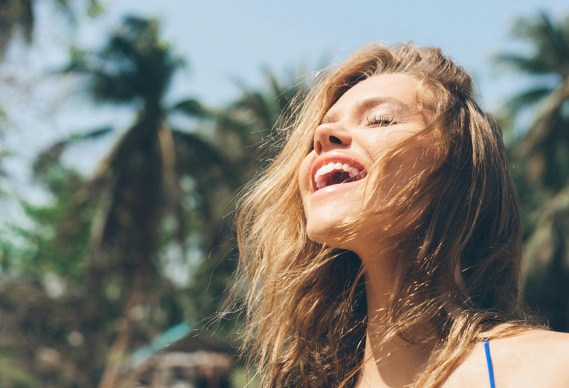 Woman smiling outside looking up towards the sky