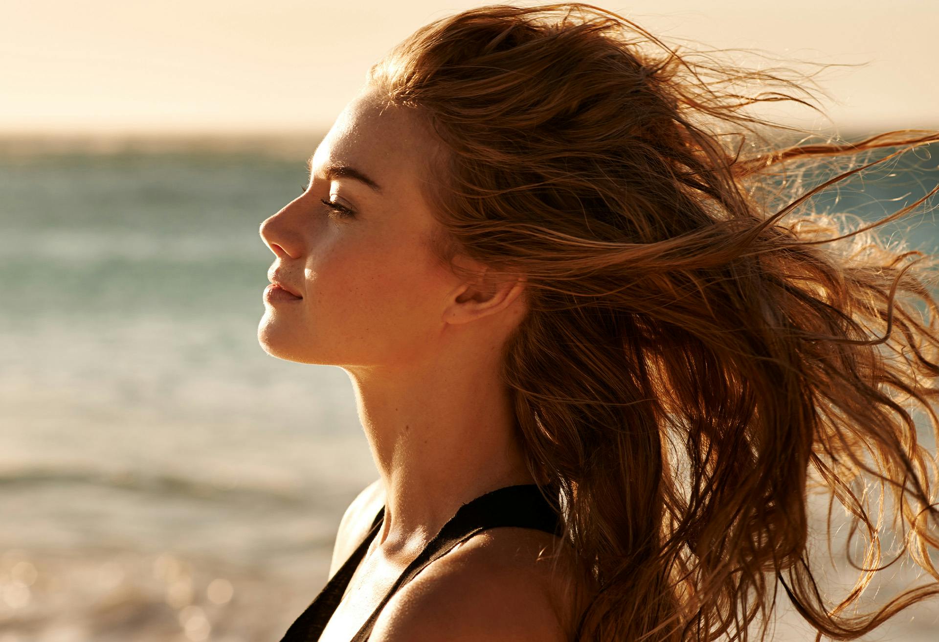 Woman at the beach with her hair blowing in the wind
