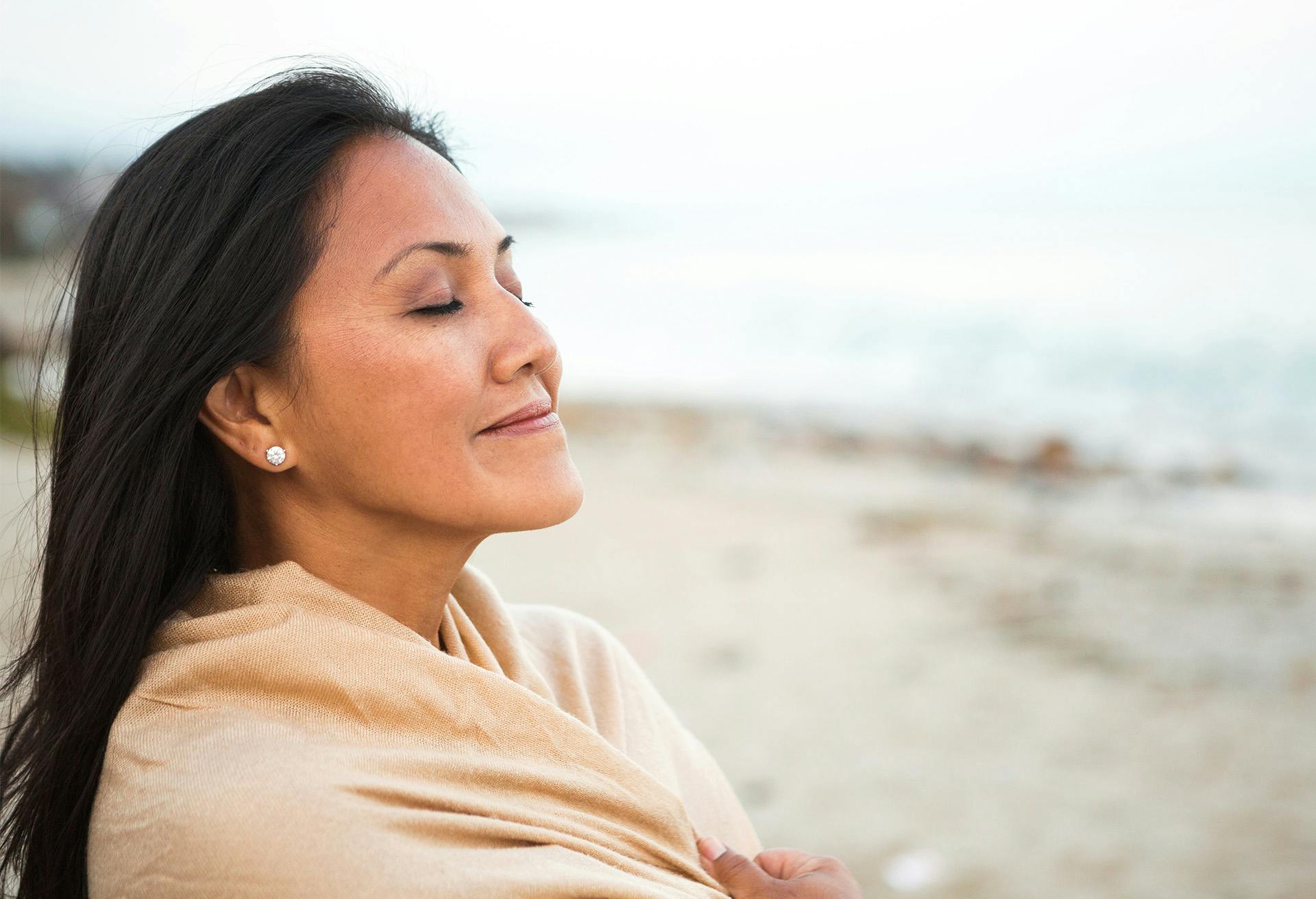 Woman at the beach with her eyes closed
