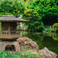 A temple garden, the usual view from a shukubo room A still temple pond with a small pavilion surrounded by clipped shrubs and trees