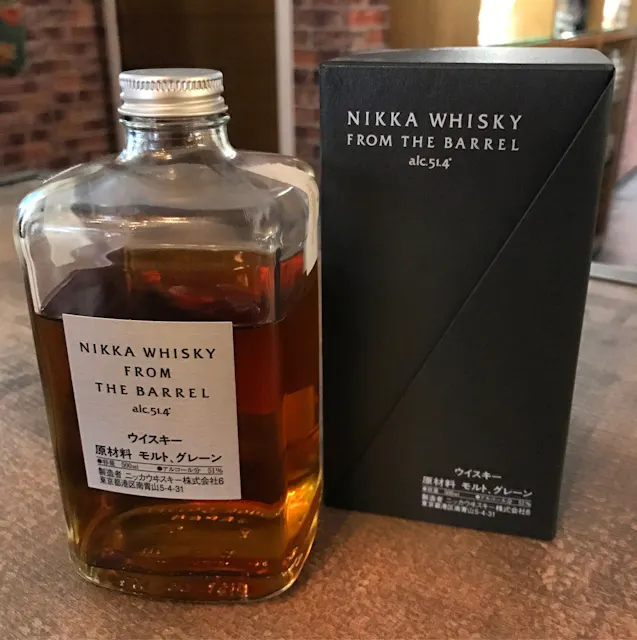 Japanese Blended Whisky A bottle of Nikka Whisky From The Barrel with its original packaging is displayed. The bottle is clear with a rectangular shape, showing amber-colored whisky inside. The box is black with white text displaying the product’s name and alcohol content of 51.4%.