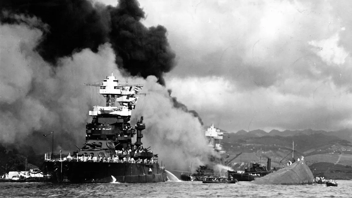 Black and white archival image of the infamous Pearl Harbor attack, showing Japanese airplanes in mid-flight during the assault, a pivotal episode in Japan's role in WW2.