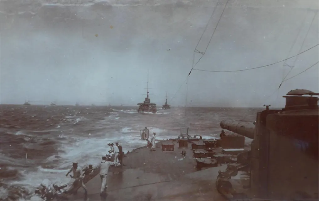 An archival image of an Imperial Japanese Navy fleet in the Battle of Tsushima, featuring a ship in the ocean with people on board.