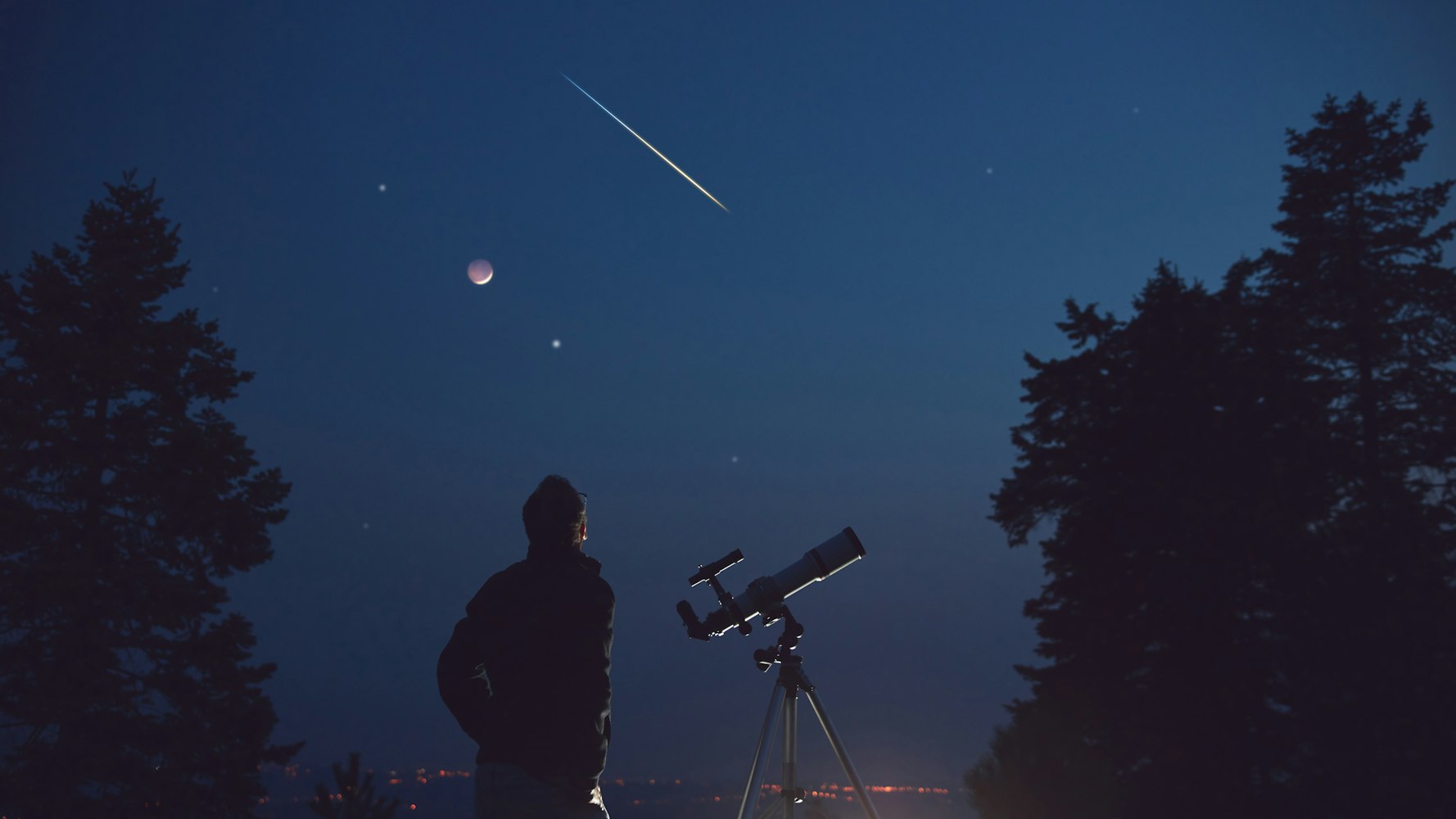 一個人站在望遠鏡旁，凝視著星星滿天、可見的行星和劃過的流星的夜空。這個場景被樹木的剪影包圍，營造出一種寧靜而令人敬畏的氛圍。