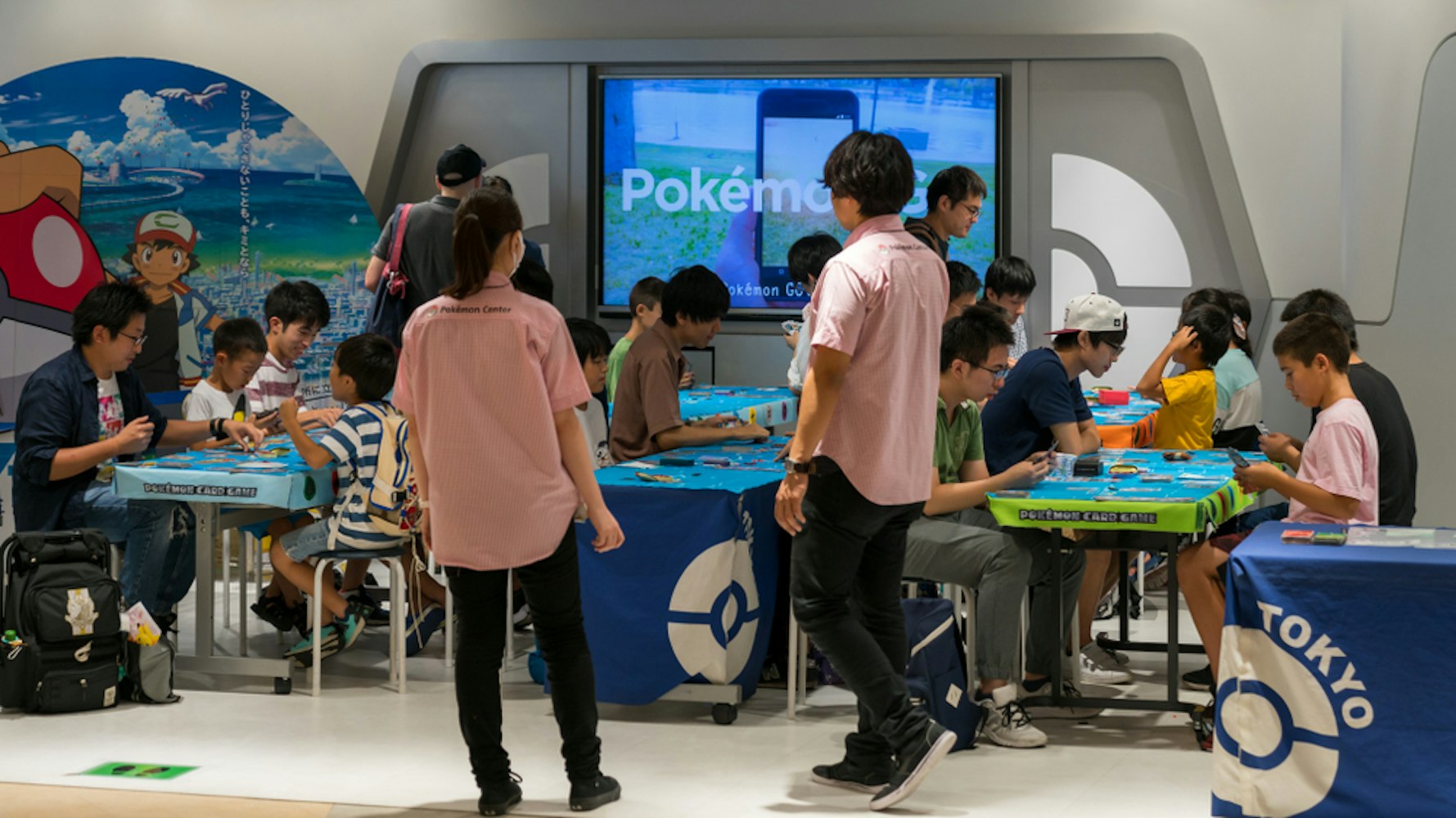 Parents with their children playing Pokemon branded arcade video games at Pokemon Center