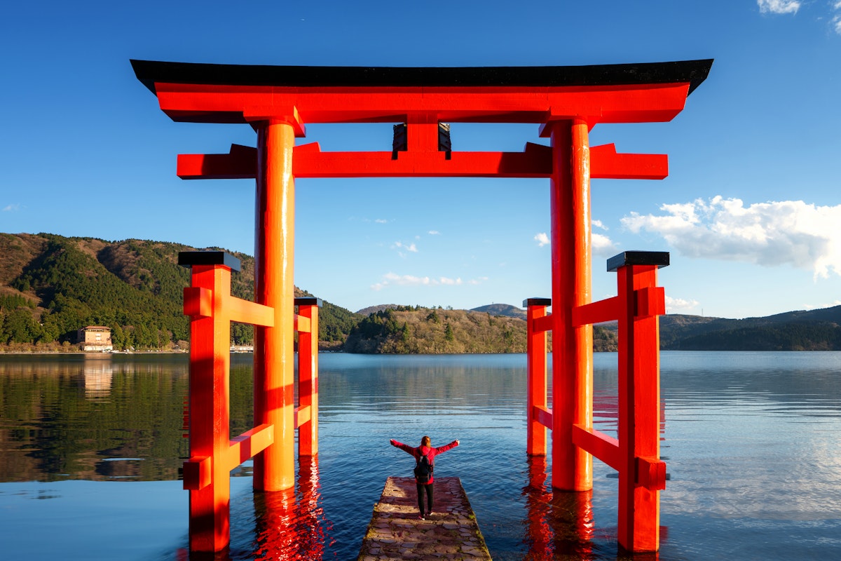 Traveller Stand on Red Torii on the Hakone Lake Traveller Stand on Red Torii on the Hakone Lake