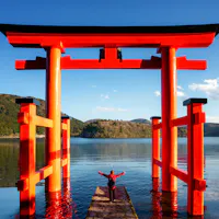 Traveller Stand on Red Torii on the Hakone Lake Traveller Stand on Red Torii on the Hakone Lake
