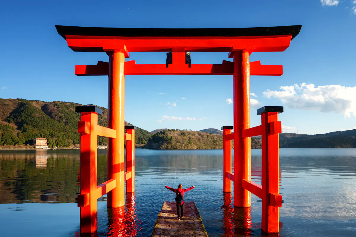 Traveller Stand on Red Torii on the Hakone Lake Traveller Stand on Red Torii on the Hakone Lake