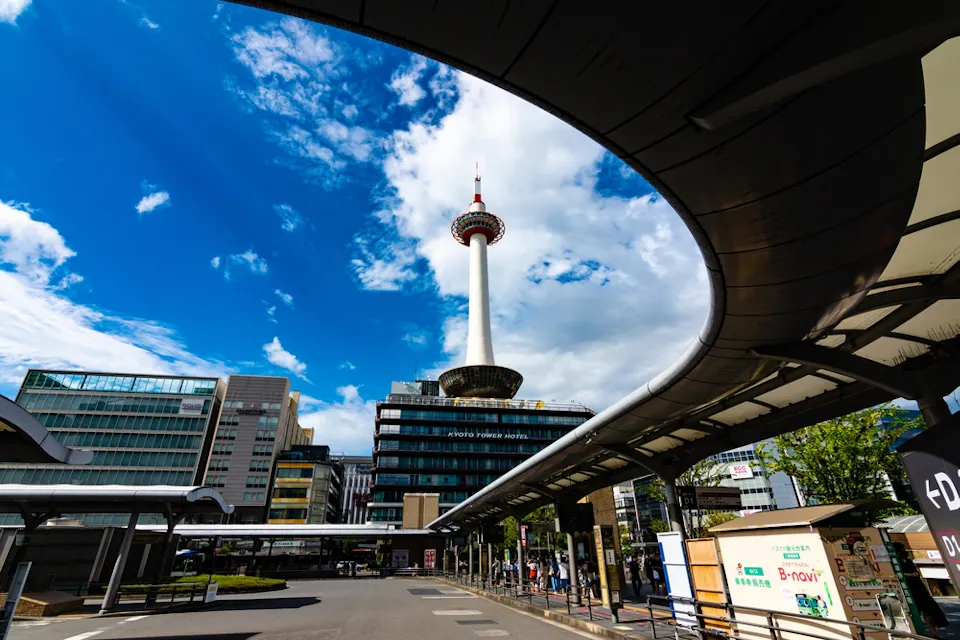 晴れた日には、中央に prominent な通信塔がある現代的な都市景観が見えます。塔の近くには円形の展望デッキがあり、周囲には現代的な建物が立ち並んでいます。いくつかの屋根付きの歩道が賑やかな都市部へと続いています。