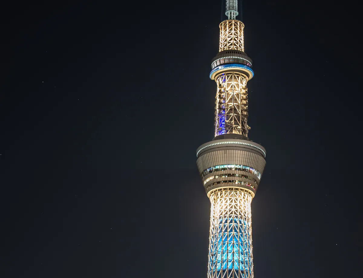 Tokyo Skytree The Tokyo Skytree illuminated at night, glowing with blue and white lights against a dark sky, highlighting its tall, modern structure and intricate design.
