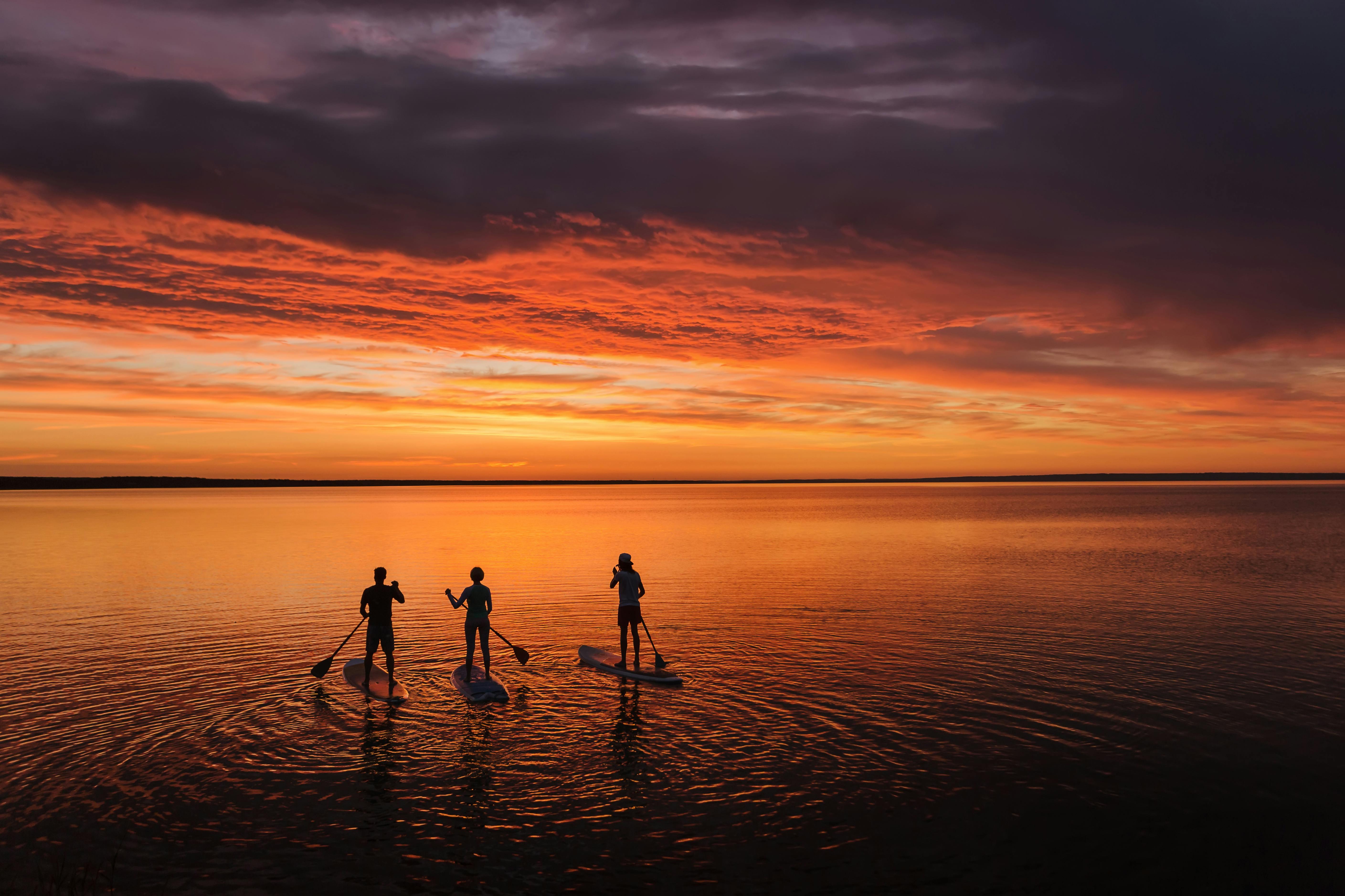 진홍빛 석양에 물든 미야코지마의 저녁. 선셋 SUP 또는 카누 투어를 선택하세요